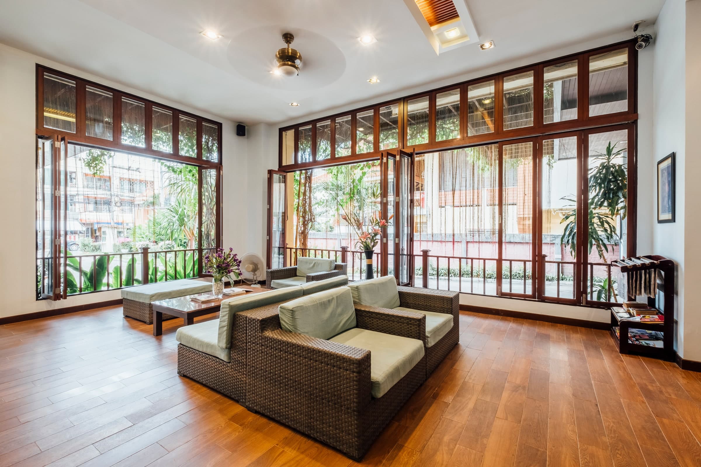 Bright hotel sitting room with wooden furniture and large windows